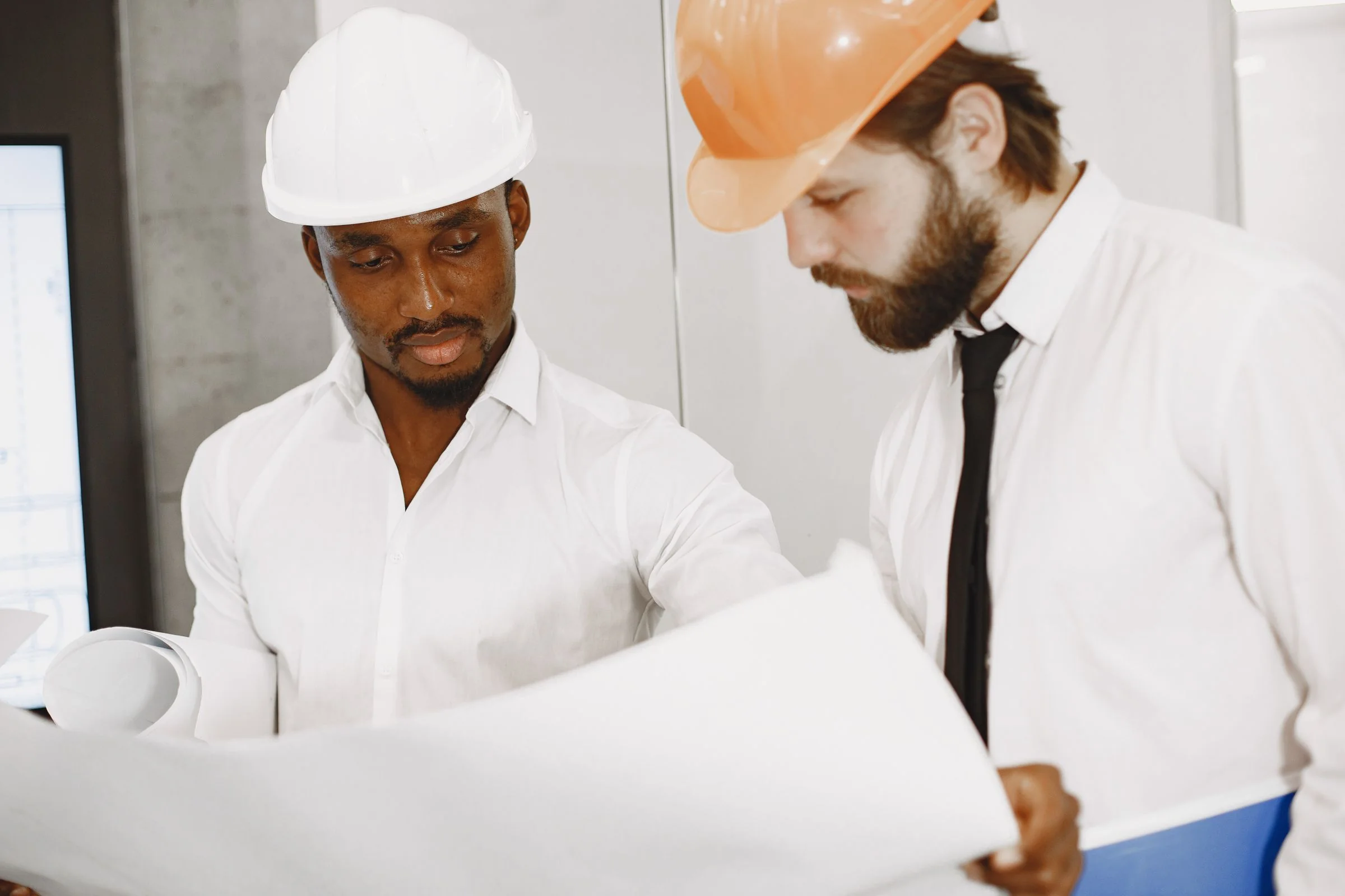 Black engineer and colleague reviewing technical plans together
