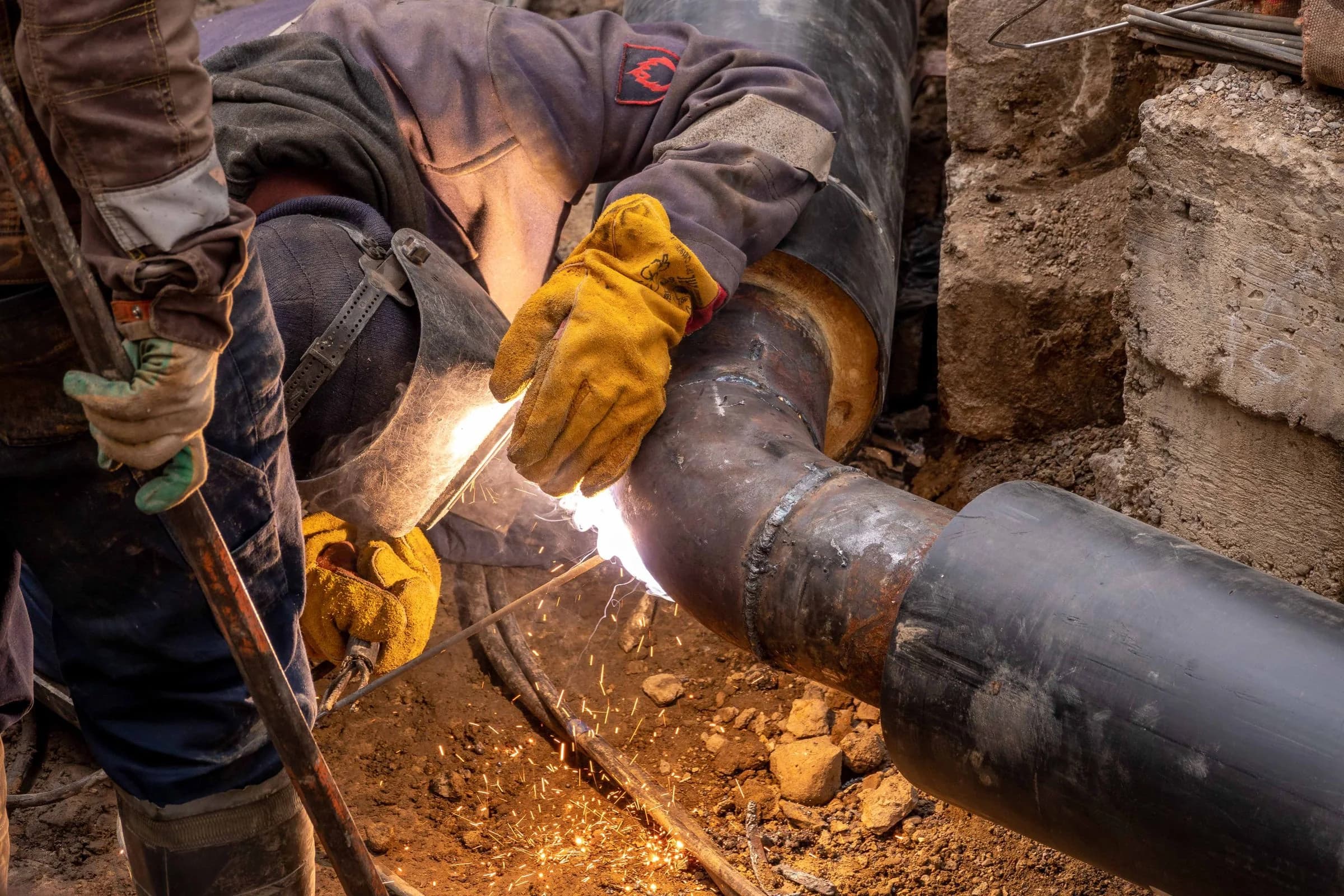 Qualified welder joining an industrial pipeline
