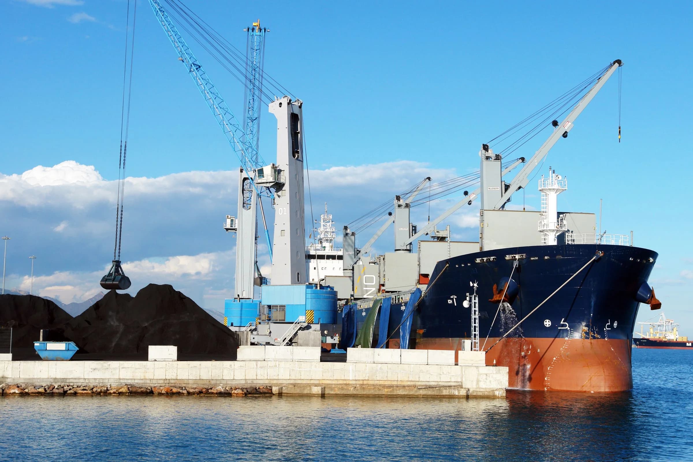 Industrial cargo vessel loading at a marine terminal