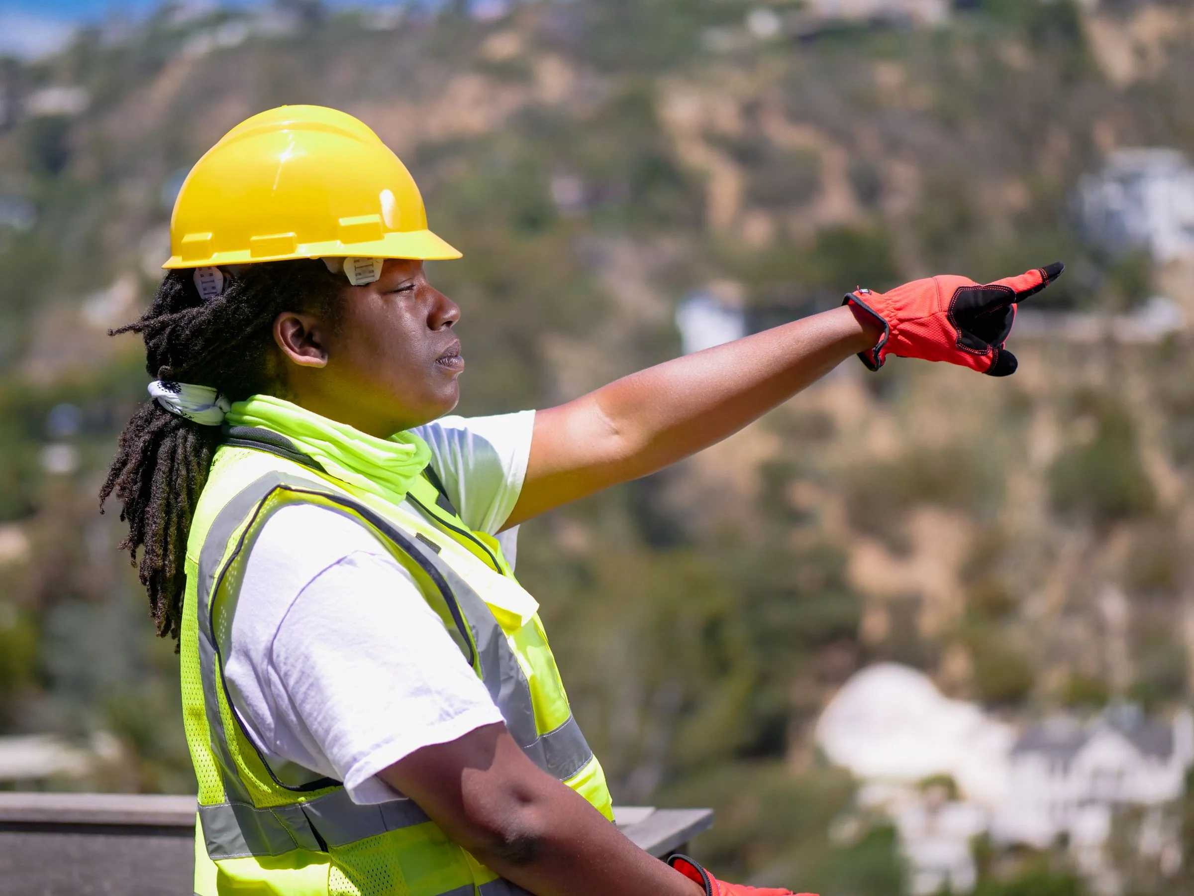 Black female engineer directing work while wearing protective equipment